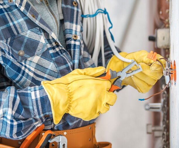 A skilled electrician using wire strippers on wiring, reflecting the hands-on electrical repair work done by the Ohio team at Great Lakes Electric.
