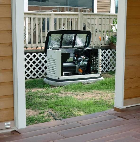 A standby generator with its cabinet open sits just off a home's back porch, ready for an inspection or service by a licensed Ohio electrician.